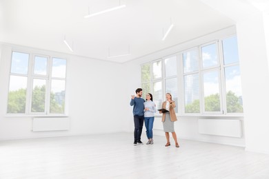 Photo of Real estate agent showing new apartment to couple