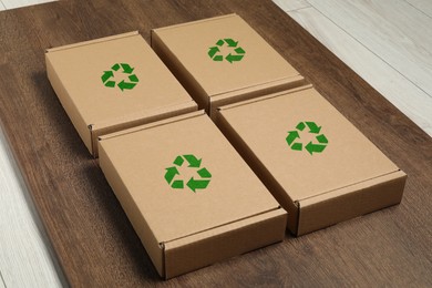 Image of Cardboard boxes with recycle sign stamps on wooden background