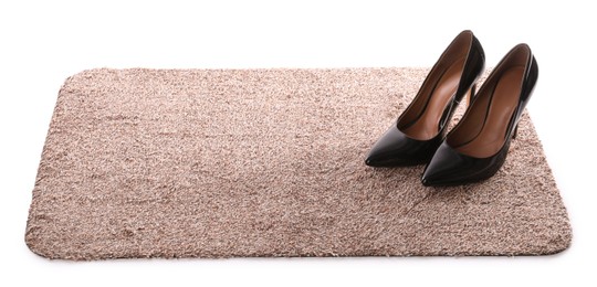 Stylish door mat with high heeled shoes on white background