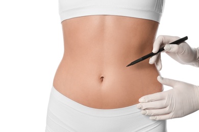 Doctor holding marker near young woman's body isolated on white, closeup. Plastic surgery concept
