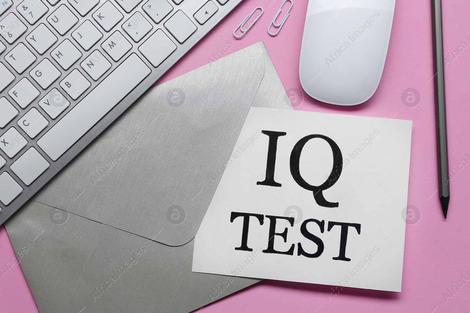 Photo of Note with text IQ Test, envelope, pencil, keyboard and mouse on pink background, flat lay