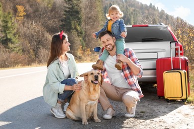 Photo of Parents, their daughter and dog outdoors. Family traveling with pet