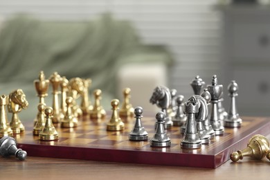 Chess board with pieces on wooden table, selective focus. Space for text