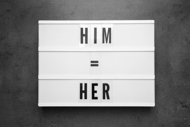 Photo of Gender equality. Lightbox with equal sign, words Him and Her on grey table, top view