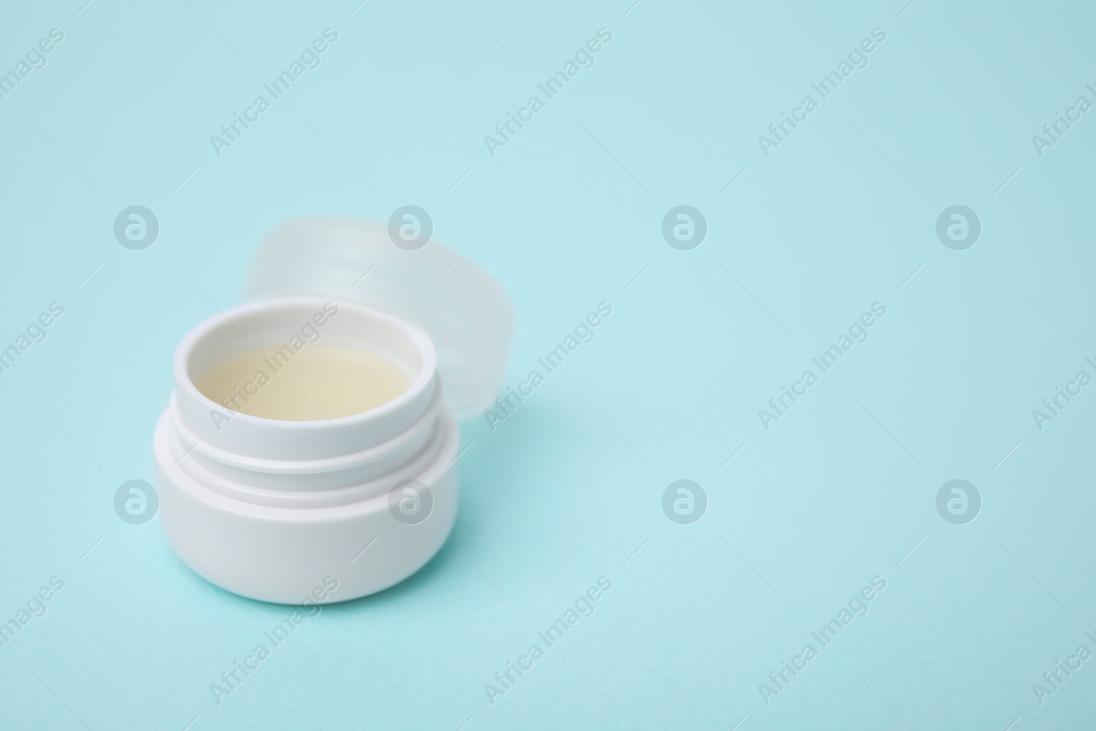 Photo of Jar of petroleum jelly on light blue background, space for text