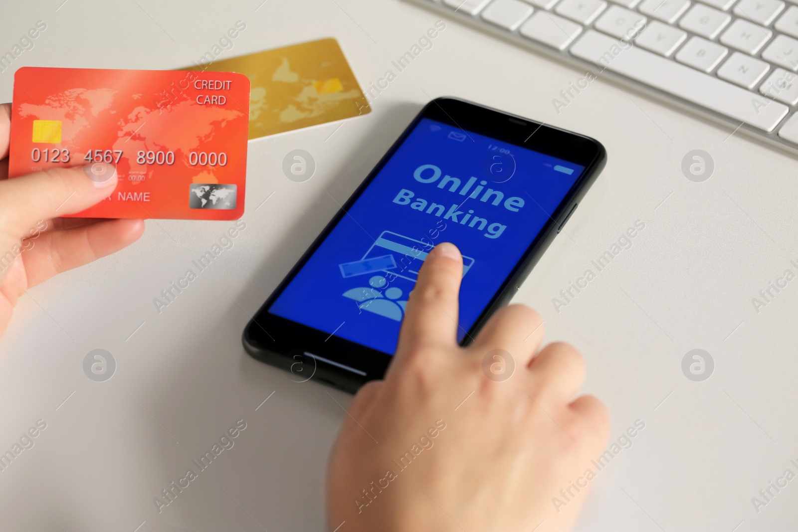 Photo of Woman using online banking app on smartphone and credit card at white office table, closeup