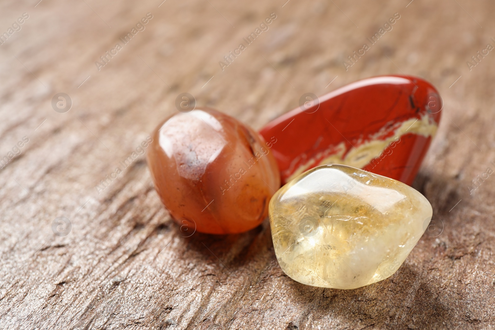 Photo of Beautiful red and white jade, carnelian agate and citrine quartz gemstones on textured surface