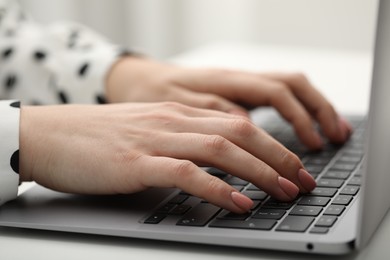 Photo of E-learning. Woman using laptop during online lesson at table indoors, closeup