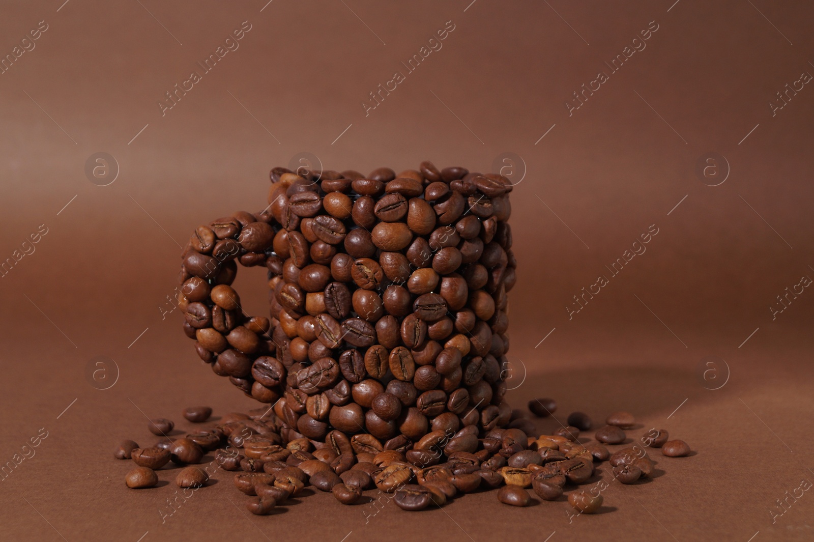 Photo of Cup made of coffee beans on brown background