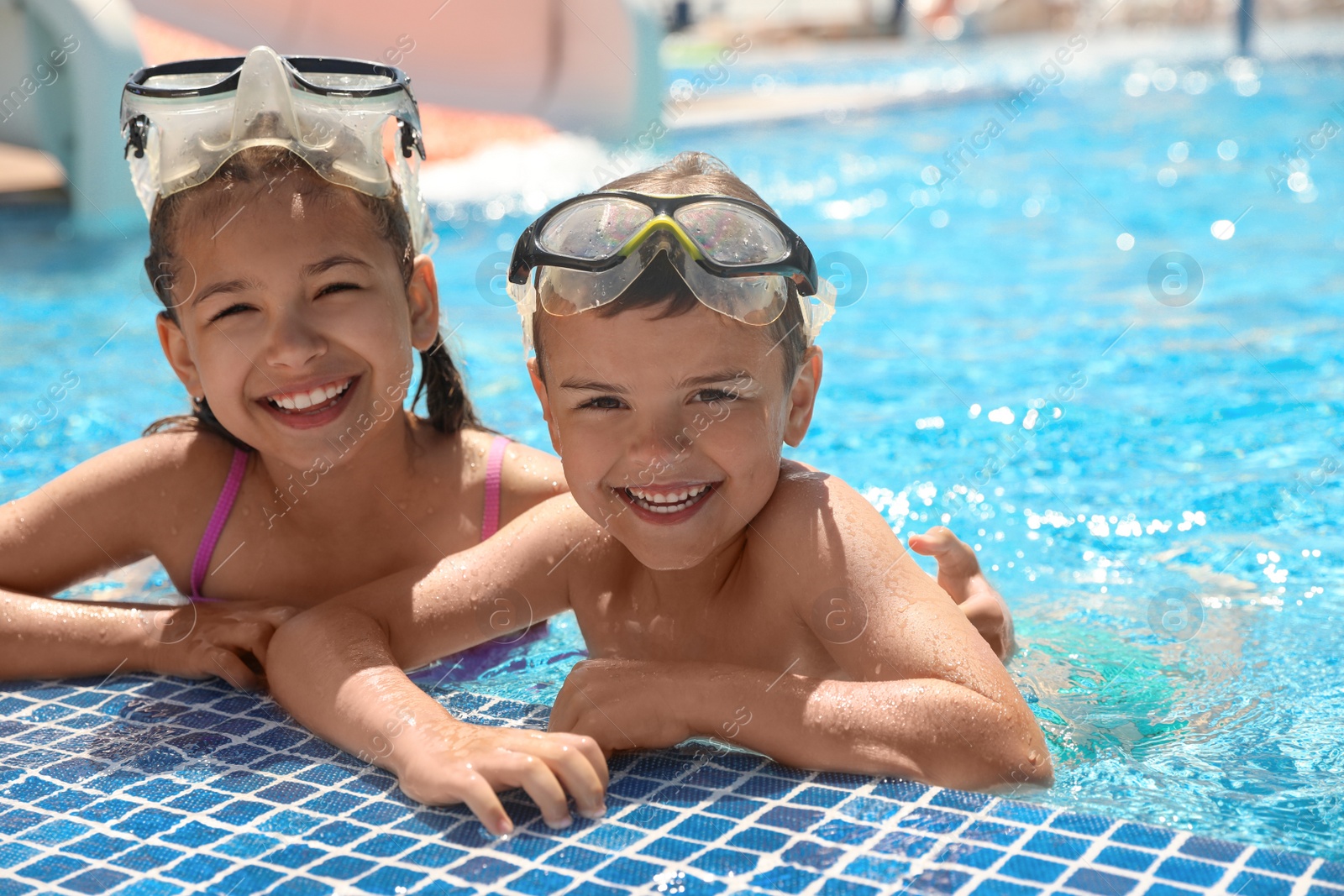 Photo of Little children wearing diving mask in swimming pool. Summer vacation