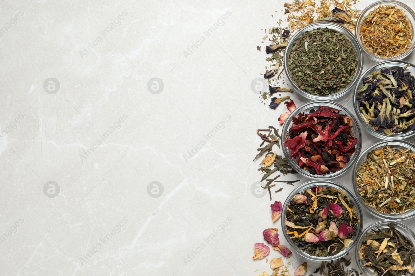 Photo of Flat lay composition with different dry teas on light table, space for text