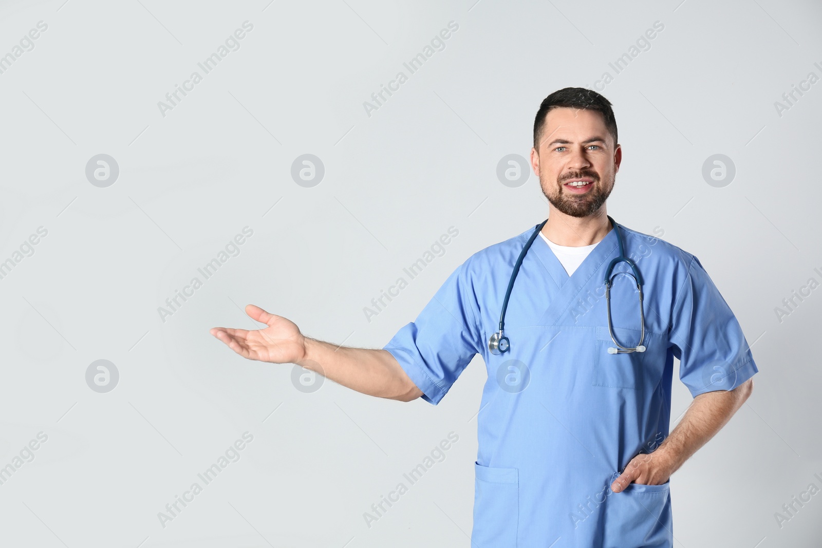 Photo of Portrait of mature doctor against light background