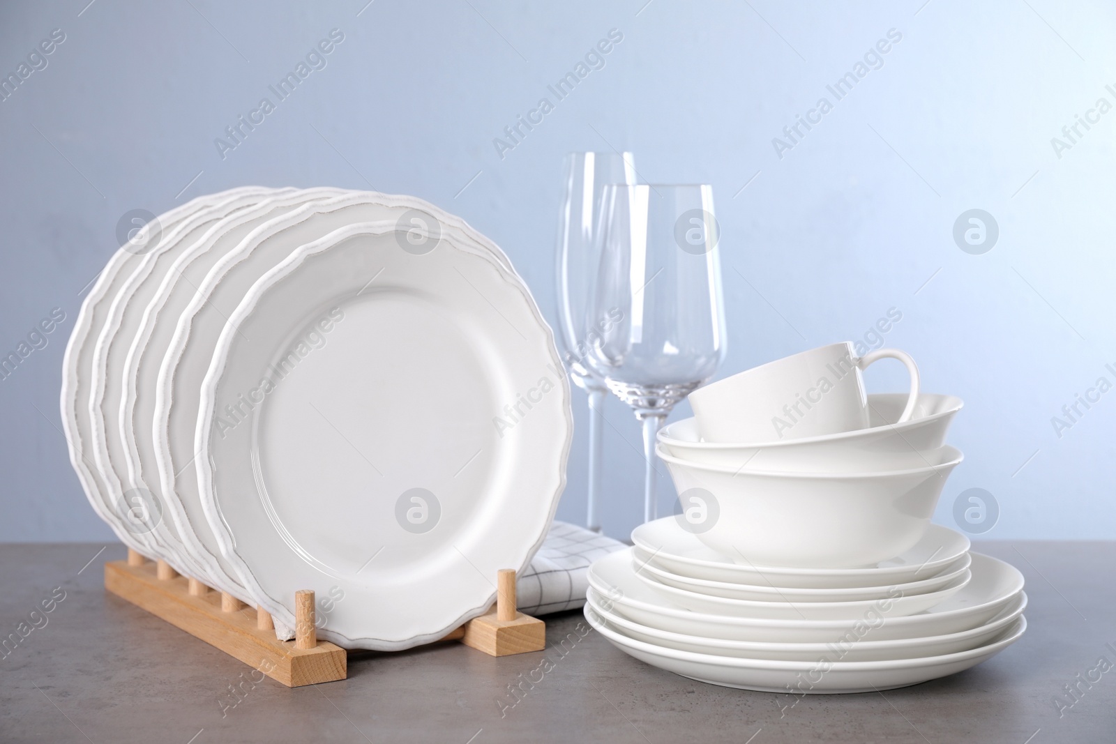 Photo of Set of clean tableware on grey table