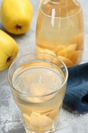 Delicious quince drink and fresh fruits on grey table, closeup