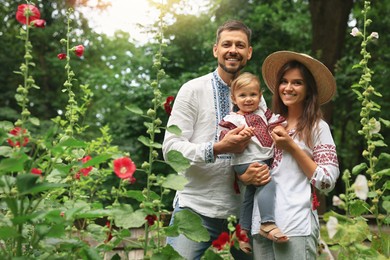 Photo of Happy family in Ukrainian national clothes outdoors