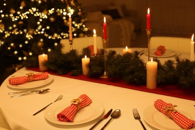 Photo of Festive table setting and beautiful Christmas decor in room. Interior design