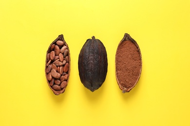 Photo of Cocoa beans, powder and pods on yellow background, flat lay