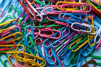 Photo of Heap of different paper clips as background, top view