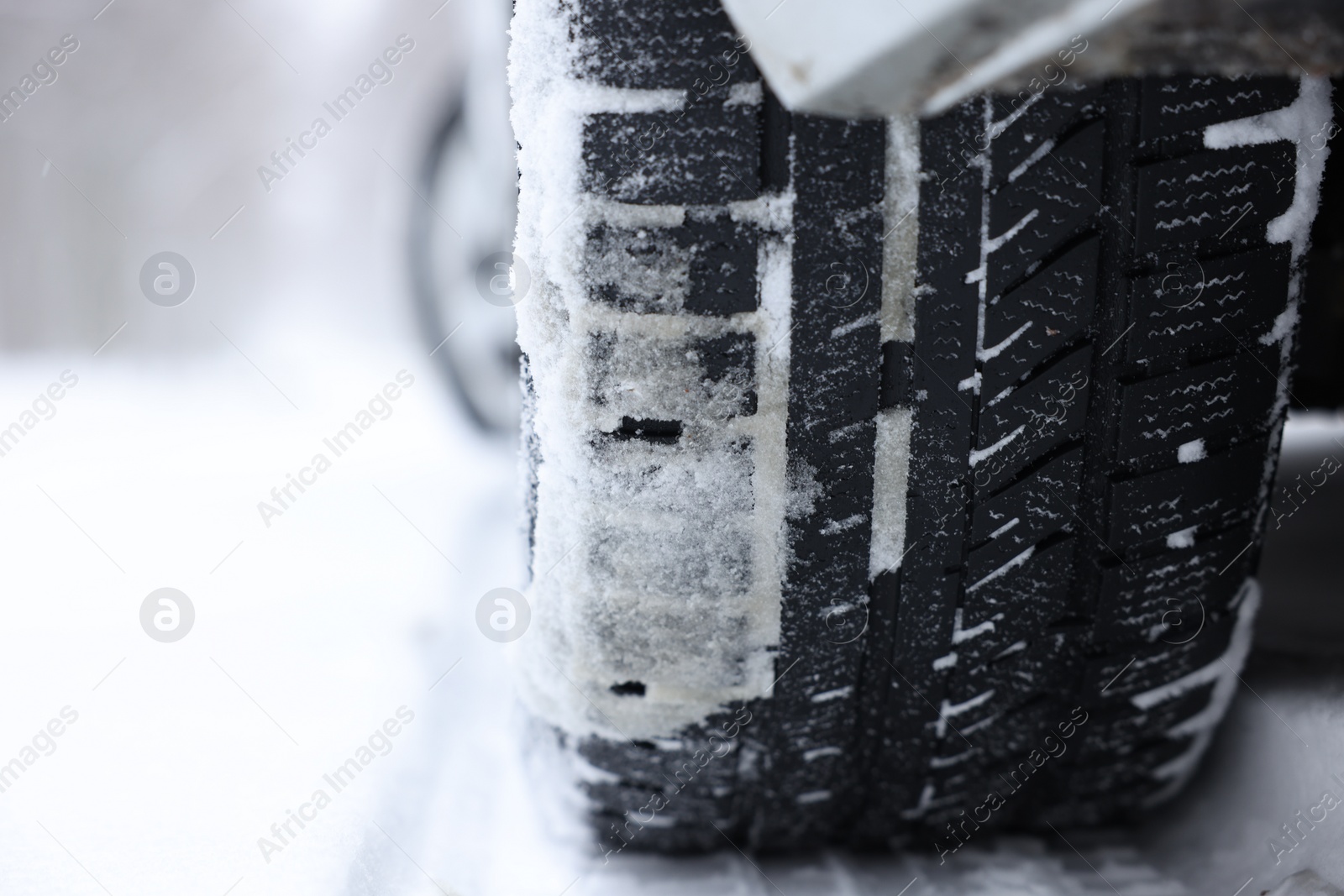 Photo of Car with winter tires on snowy road outdoors, closeup. Space for text