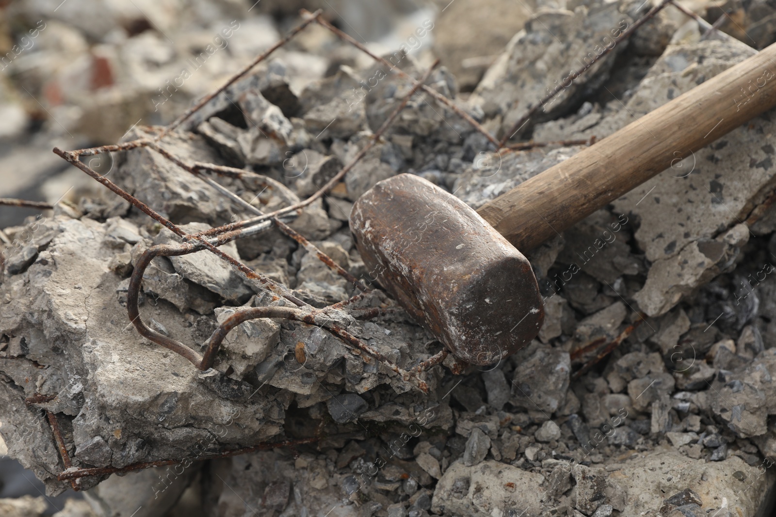 Photo of Sledgehammer on pile of broken stones outdoors, closeup