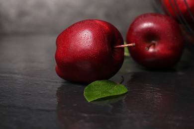 Ripe red apples with water drops on dark grey table