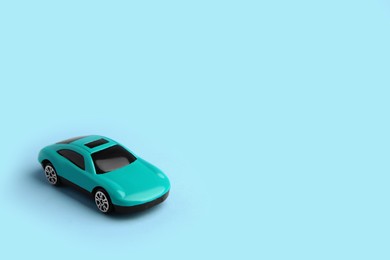 One bright car on light blue background, space for text. Children`s toy