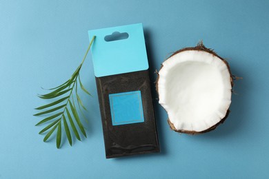 Photo of Scented sachet, piece of coconut and leaf on blue background, flat lay