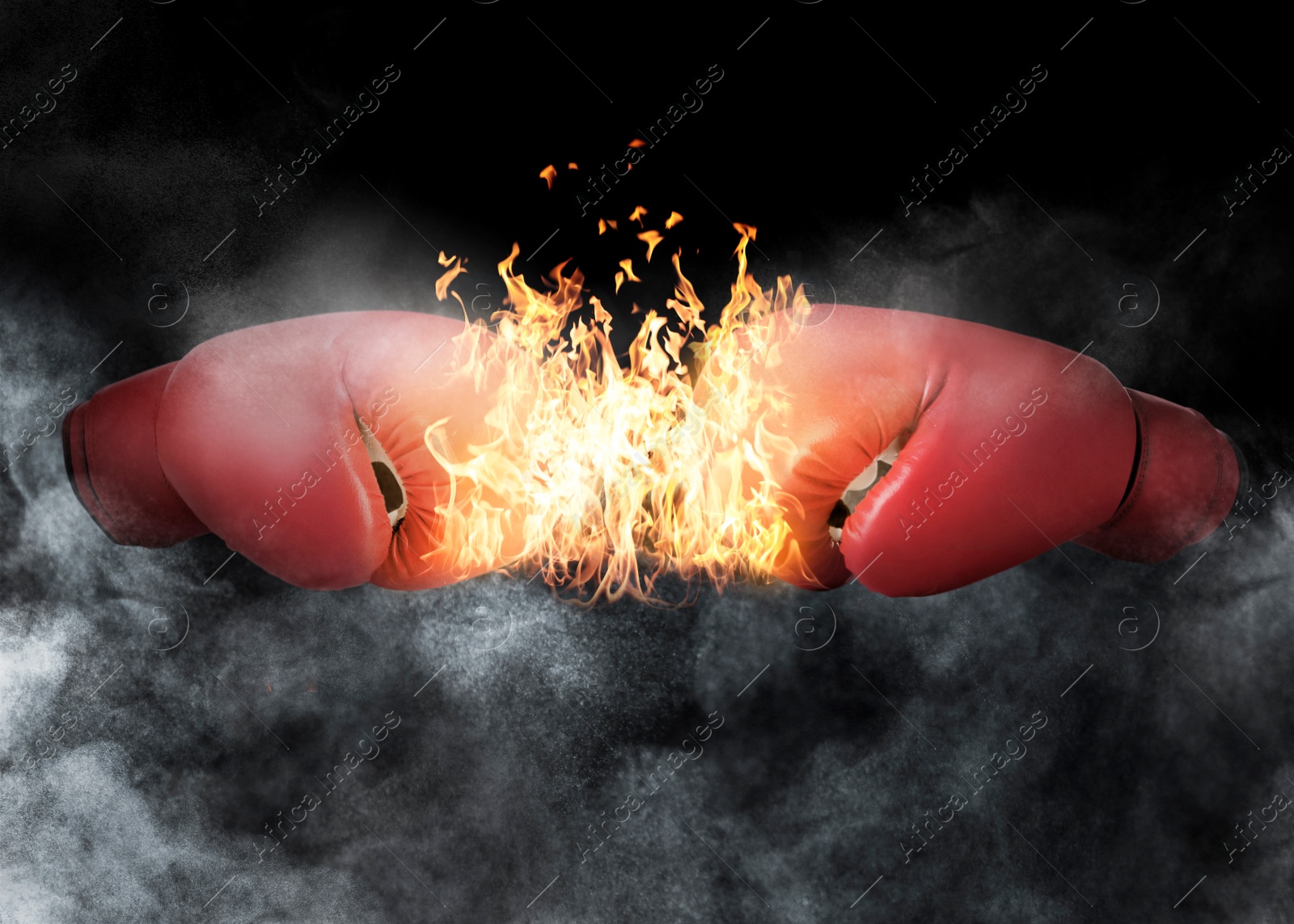 Image of Boxing gloves with flame opposing each other against black background