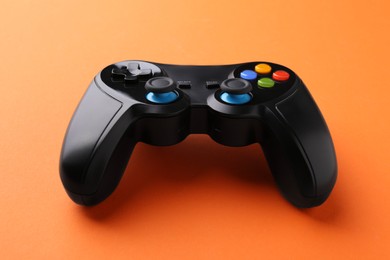 Photo of One wireless game controller on orange background