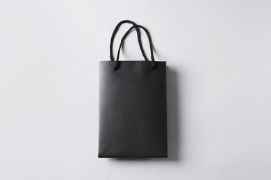 Photo of Black paper bag on light grey background, top view