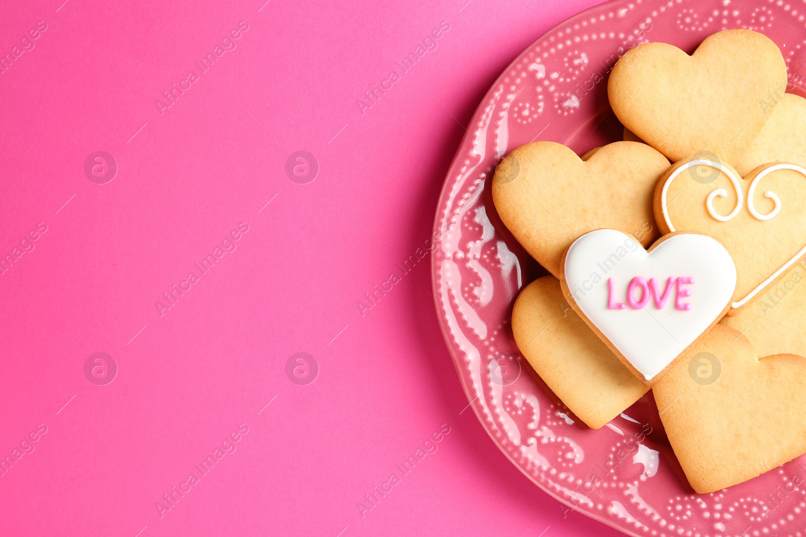 Photo of Plate with decorated heart shaped cookies and space for text on color background, top view. Valentine's day treat