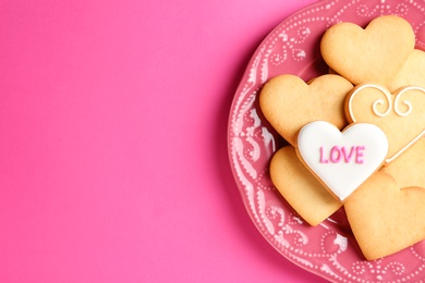 Photo of Plate with decorated heart shaped cookies and space for text on color background, top view. Valentine's day treat