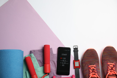 Photo of Flat lay composition with fitness equipment and smartphone on color background, space for text