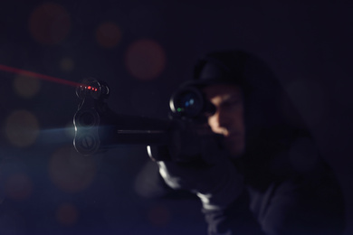 Photo of Professional killer on black background, focus on sniper rifle