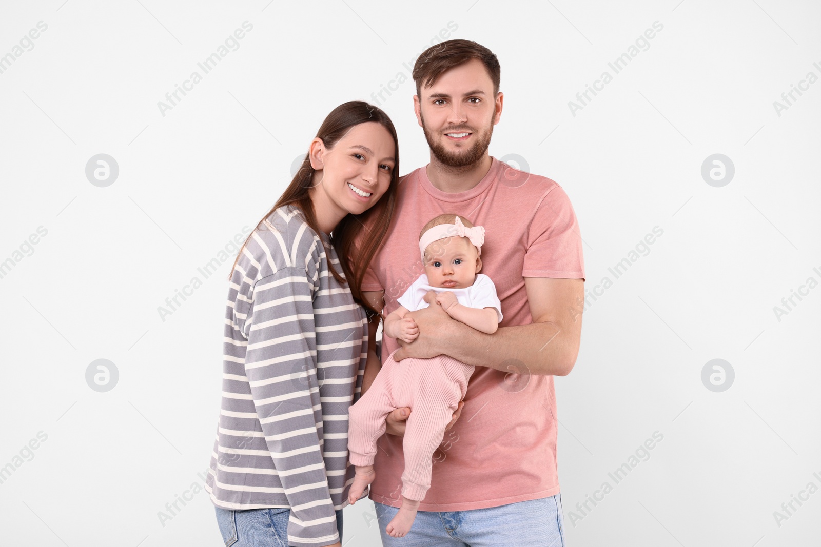 Photo of Happy family. Parents with their cute baby on light background