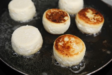 Photo of Delicious cottage cheese pancakes in frying pan, closeup