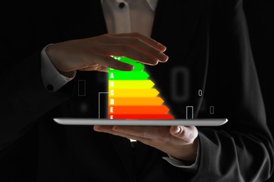 Image of Energy efficiency rating coming out of tablet. Man using device, closeup