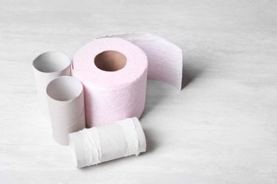 Photo of Toilet paper roll and empty tubes on wooden background. Space for text