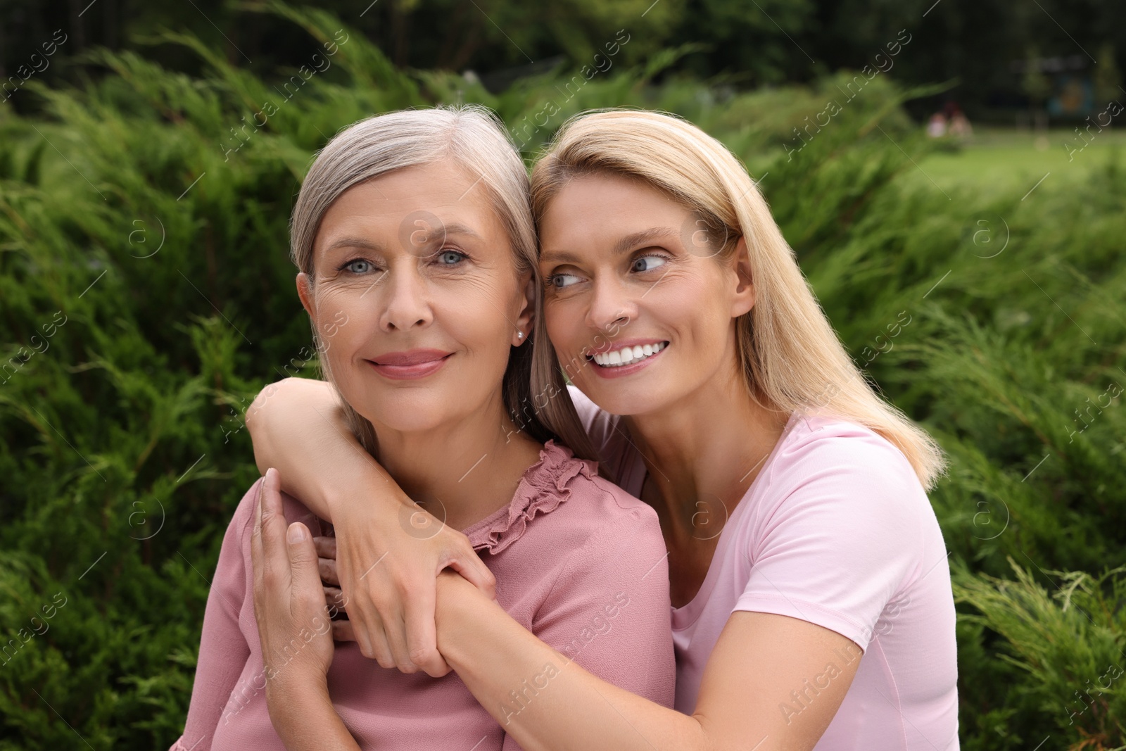 Photo of Happy mature mother and her daughter hugging outdoors