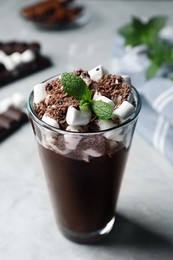 Photo of Glass of delicious hot chocolate with marshmallows and fresh mint on light grey table