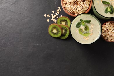 Photo of Glass of tasty kiwi smoothie with oatmeal on dark table, flat lay. Space for text