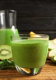 Photo of Tasty fresh kale smoothie on wooden table