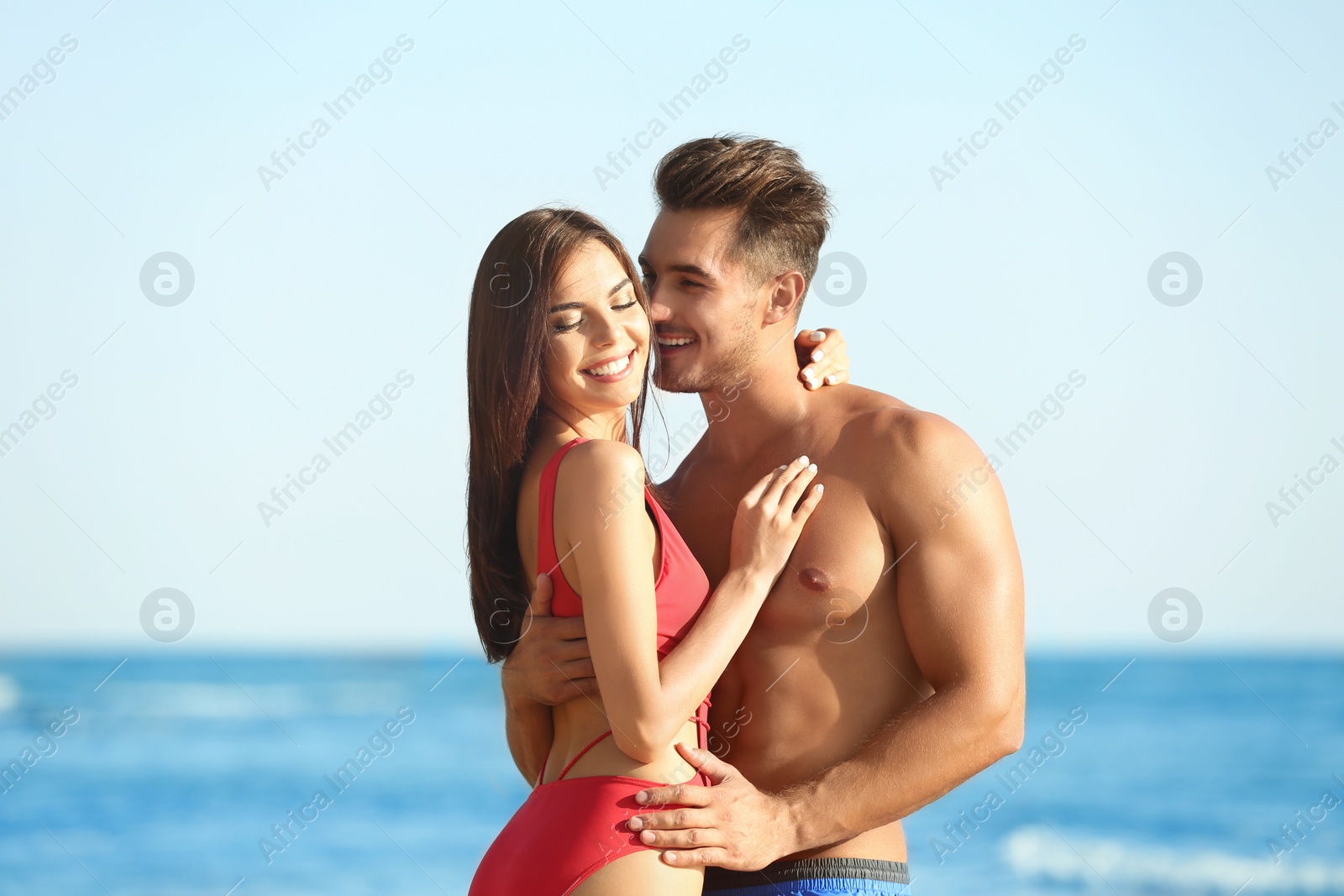 Photo of Happy young couple posing near sea on beach