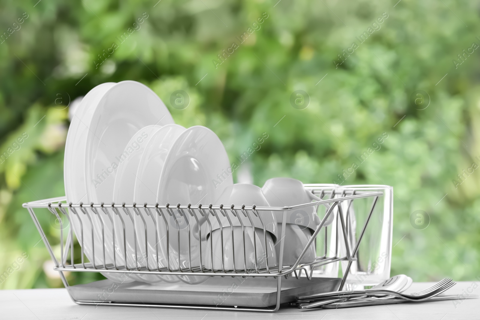 Photo of Set of clean dishware on table against blurred background