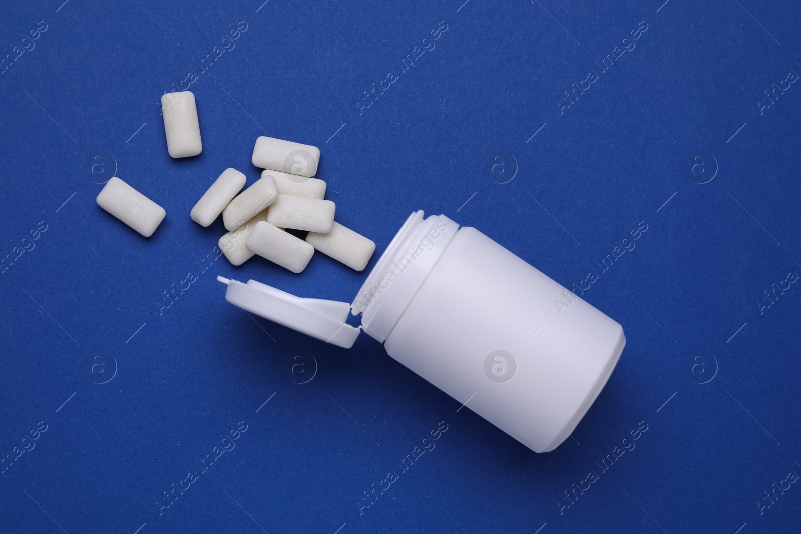 Photo of Jar with chewing gums on blue background, flat lay