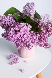 Photo of Beautiful lilac flowers in vase on white table