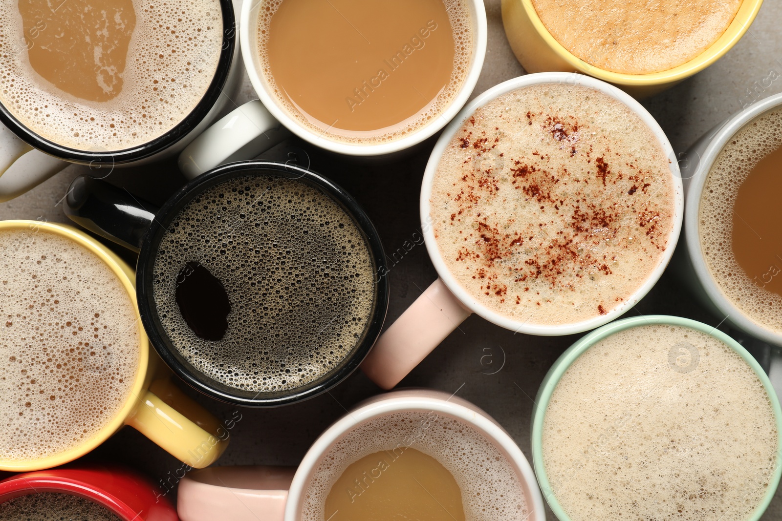 Photo of Many cups with different aromatic coffee on grey table, flat lay