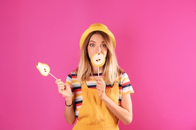 Photo of Young pretty woman with candies on colorful background