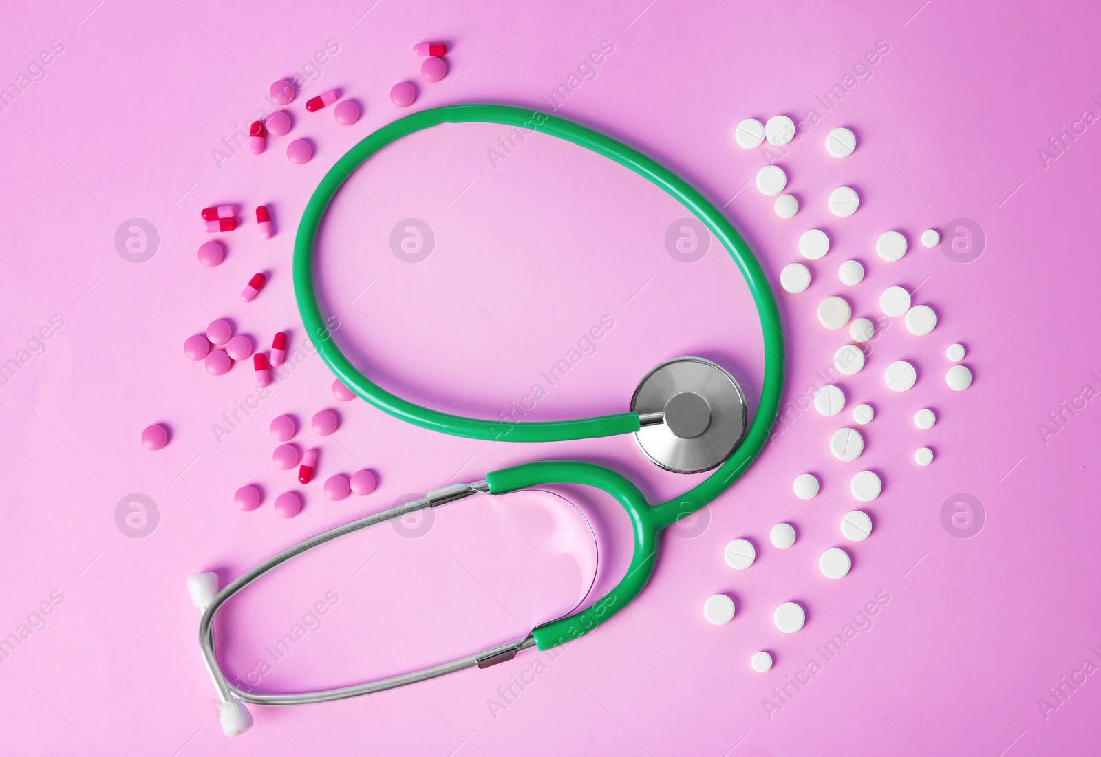 Photo of Flat lay composition with stethoscope and pills on color background. Gynecological checkup