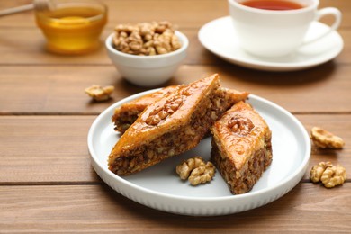 Delicious honey baklava with walnuts served on wooden table